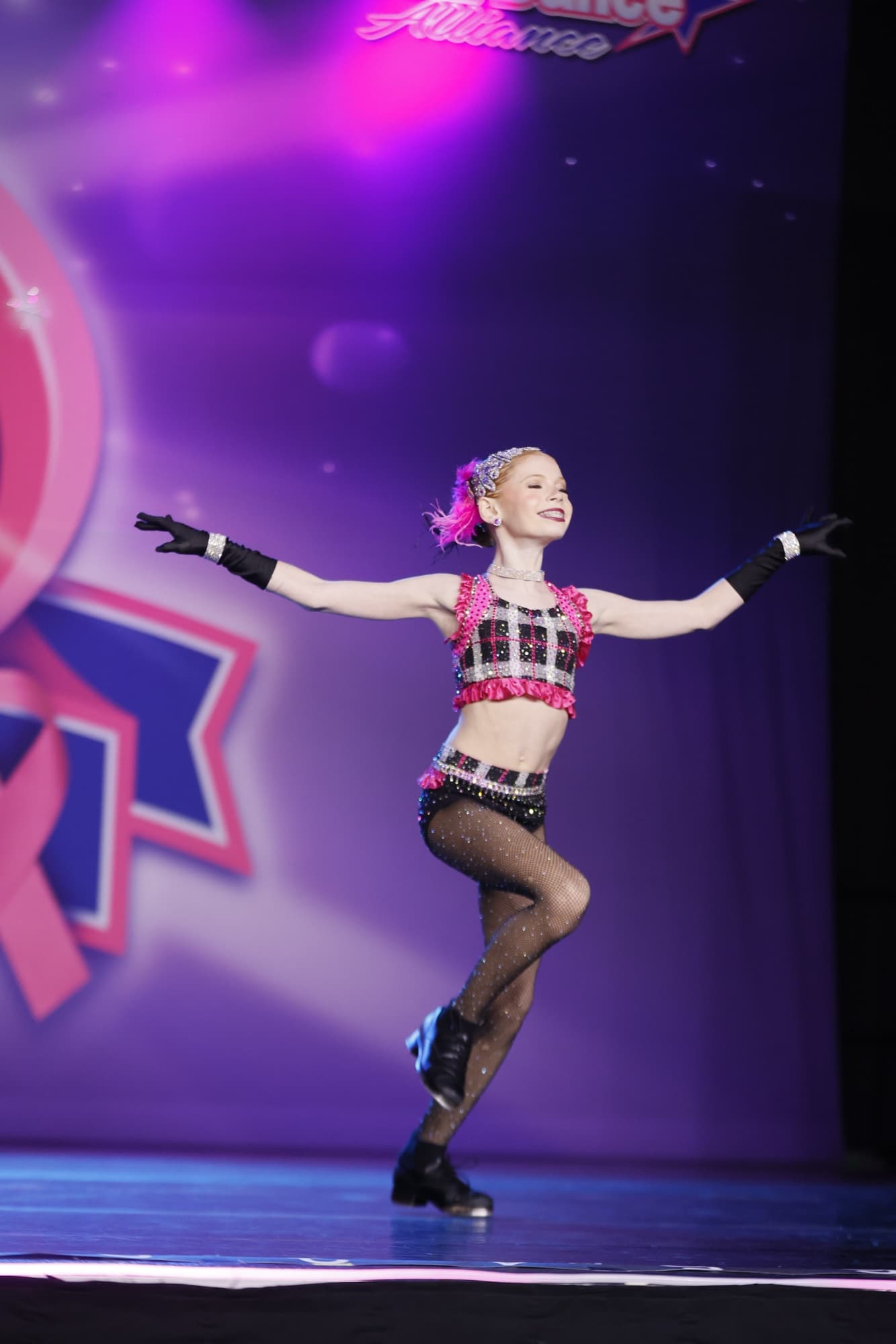 A DXNY dancer captured mid-performance, smiling