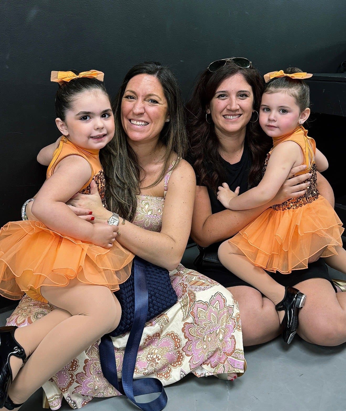 Moms and toddlers in orange tutus at DXNY